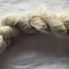 skein of natural cream yarn on a white background