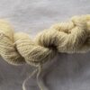 A single skein of pale yellow blue faced Leicester yarn with the batch number 252