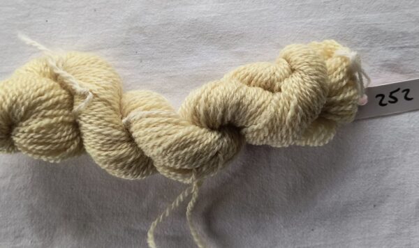 A single skein of pale yellow blue faced Leicester yarn with the batch number 252