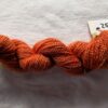 twisted skein of russet red yarn on a white background