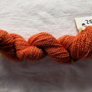 twisted skein of russet red yarn on a white background