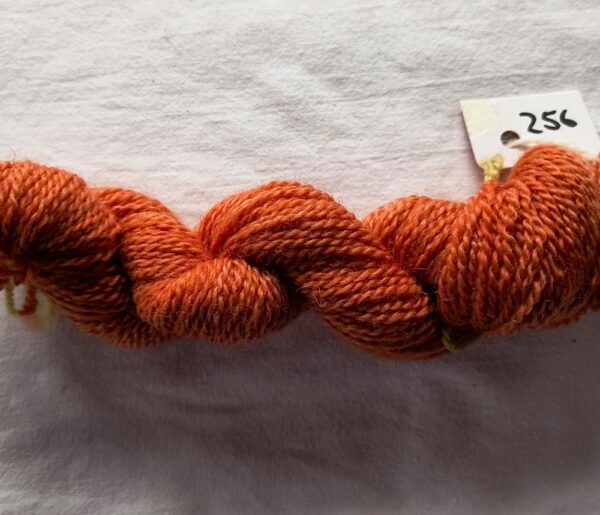 twisted skein of russet red yarn on a white background