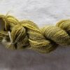 skein of mottled yellow and green yarn on a white background