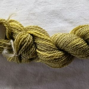 skein of mottled yellow and green yarn on a white background