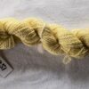 twisted skein of yellow yarn on a white background