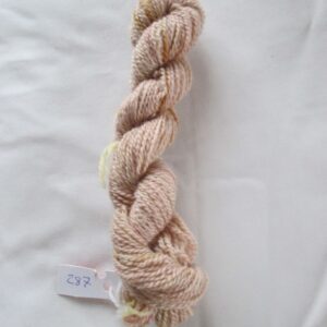 twisted skein of brown yarn on a white background with a label numbered 287