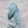 turquoise blue skein of aran weight yarn on a white background with a label 275